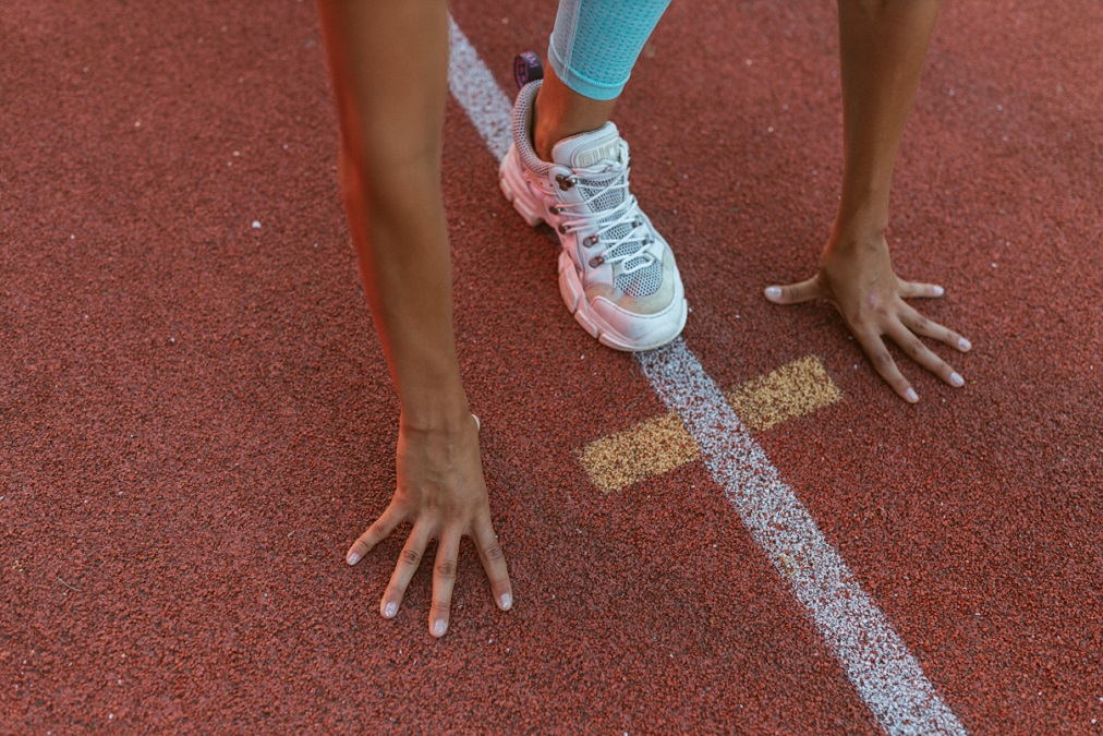 A runner stands ready at the starting line of a track.