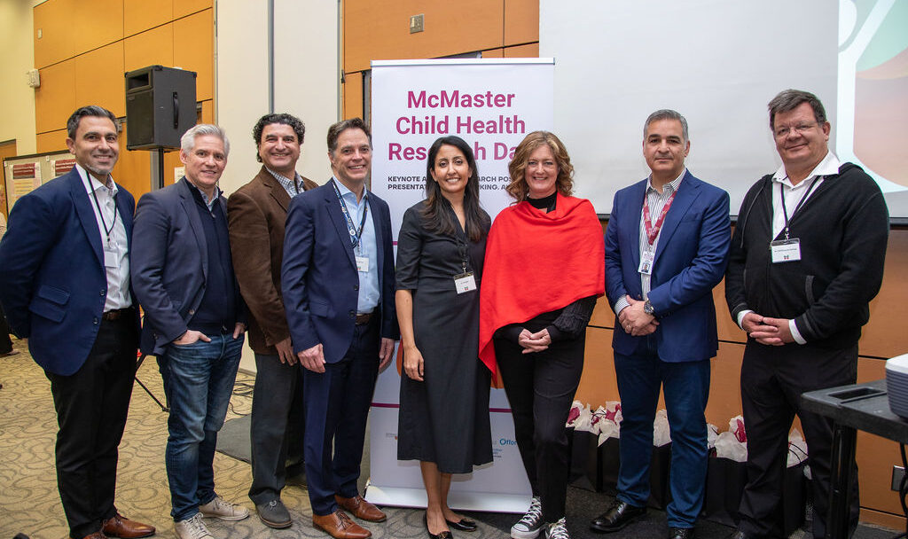 Several McMaster leaders and special guests standing shoulder to shoulder at the McMaster Child Health Research Day event.