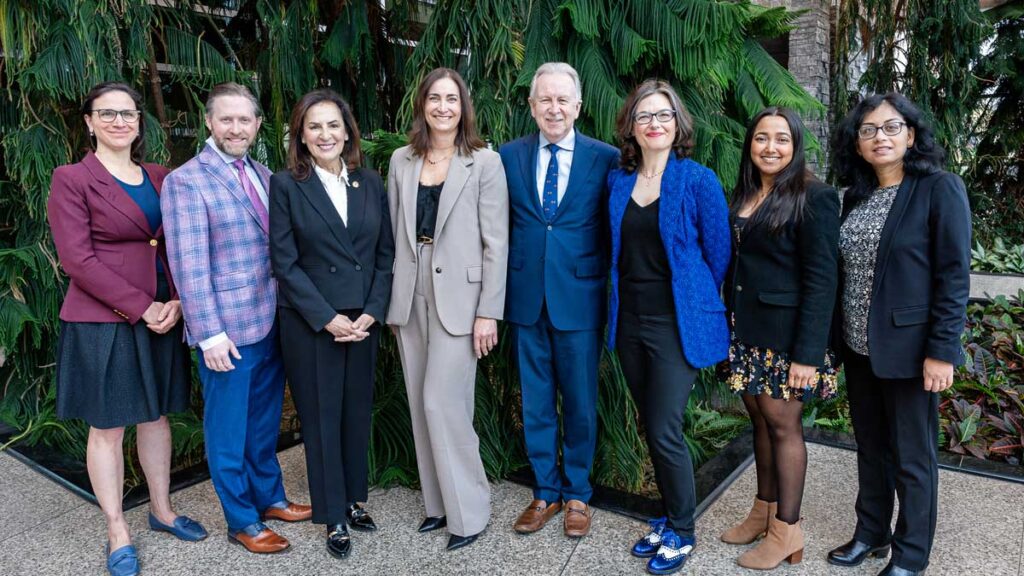 Fiona Kouyoumdjian, Matthew Miller, Effie Triantafilopoulos, Andréa Mueller, Paul O'Byrne, Dawn Bowdish, Sudeshna Dhar and Chandrima Chakraborty pose in the atrium of the Michael G. DeGroote Centre for Learning and Discovery.