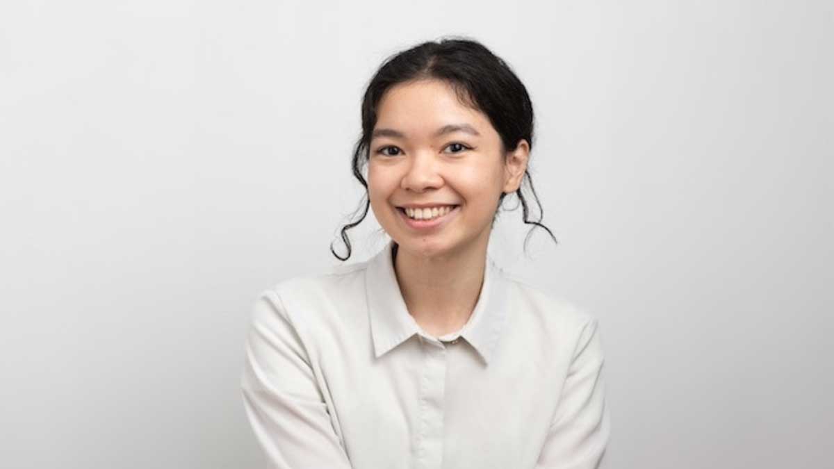 Smiling headshot of Fei Mu against a white backdrop, wearing a light-coloured shirt
