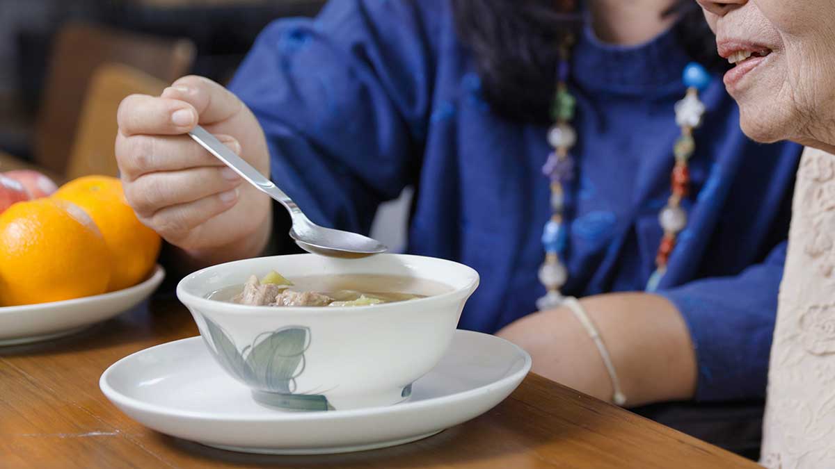 A person eating soup with a spoon