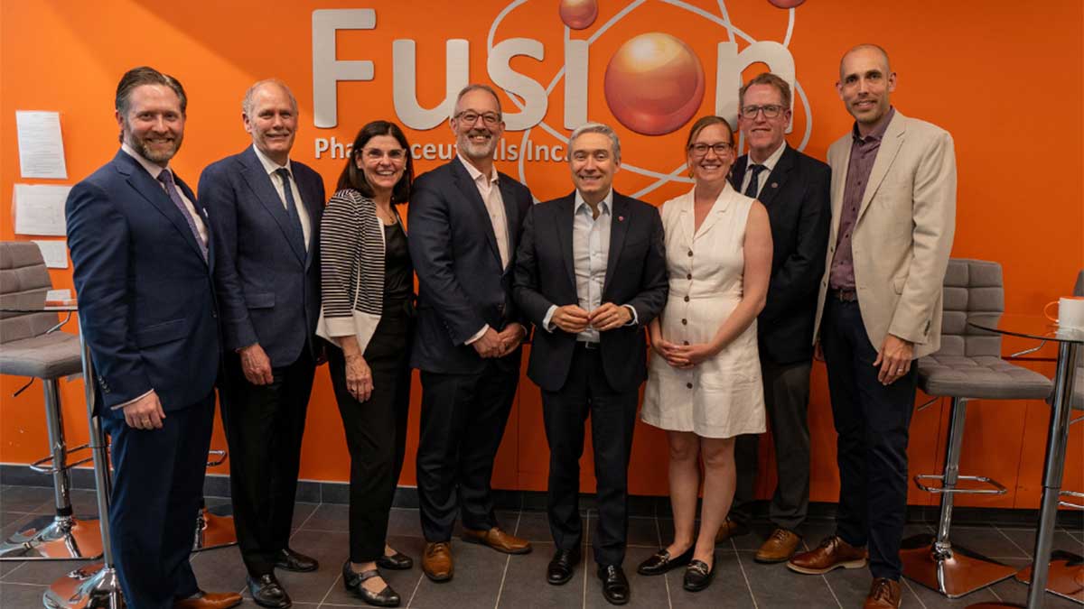 Eight people standing in front of a sign that reads, ‘Fusion Pharmaceuticals Inc.’