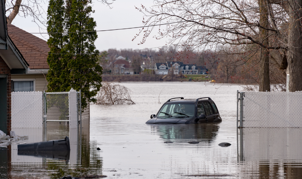 A vehicle can be seen partially submerged in flood waters.