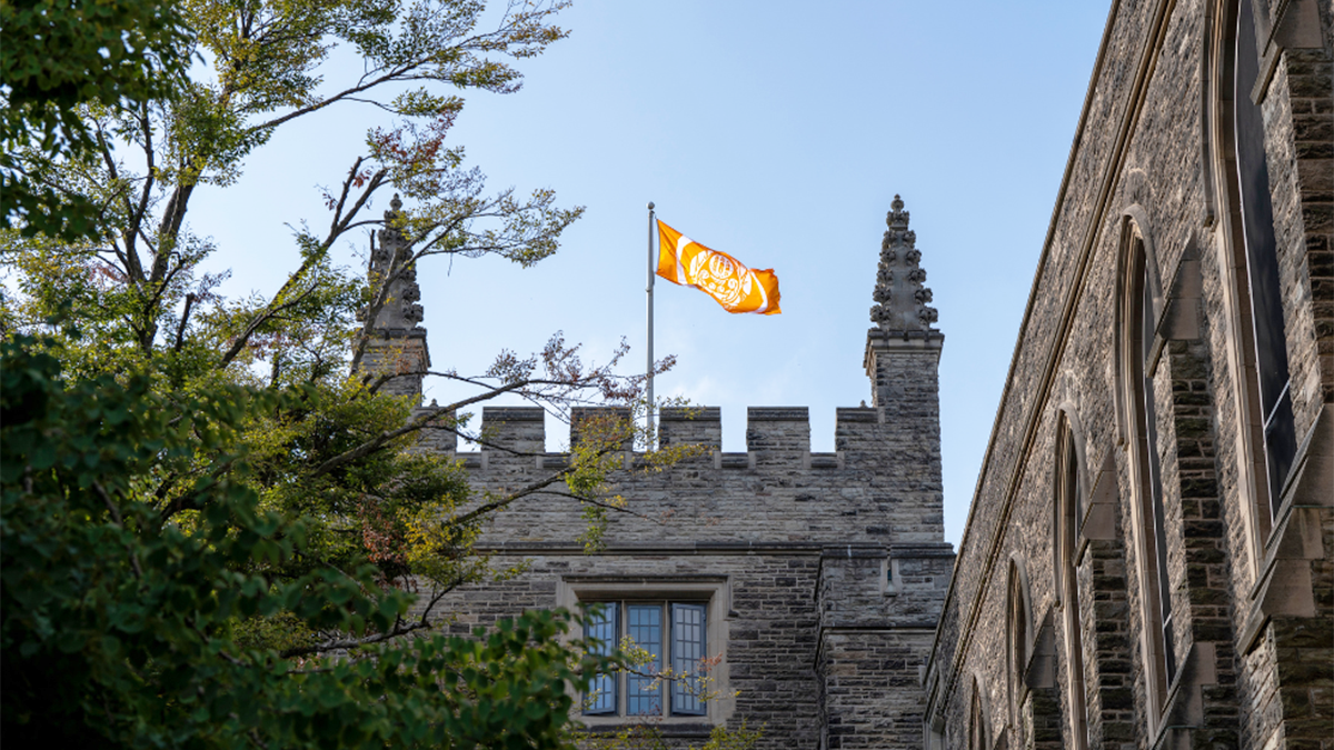 An orange flag flying on top of University Hall on McMaster's campus