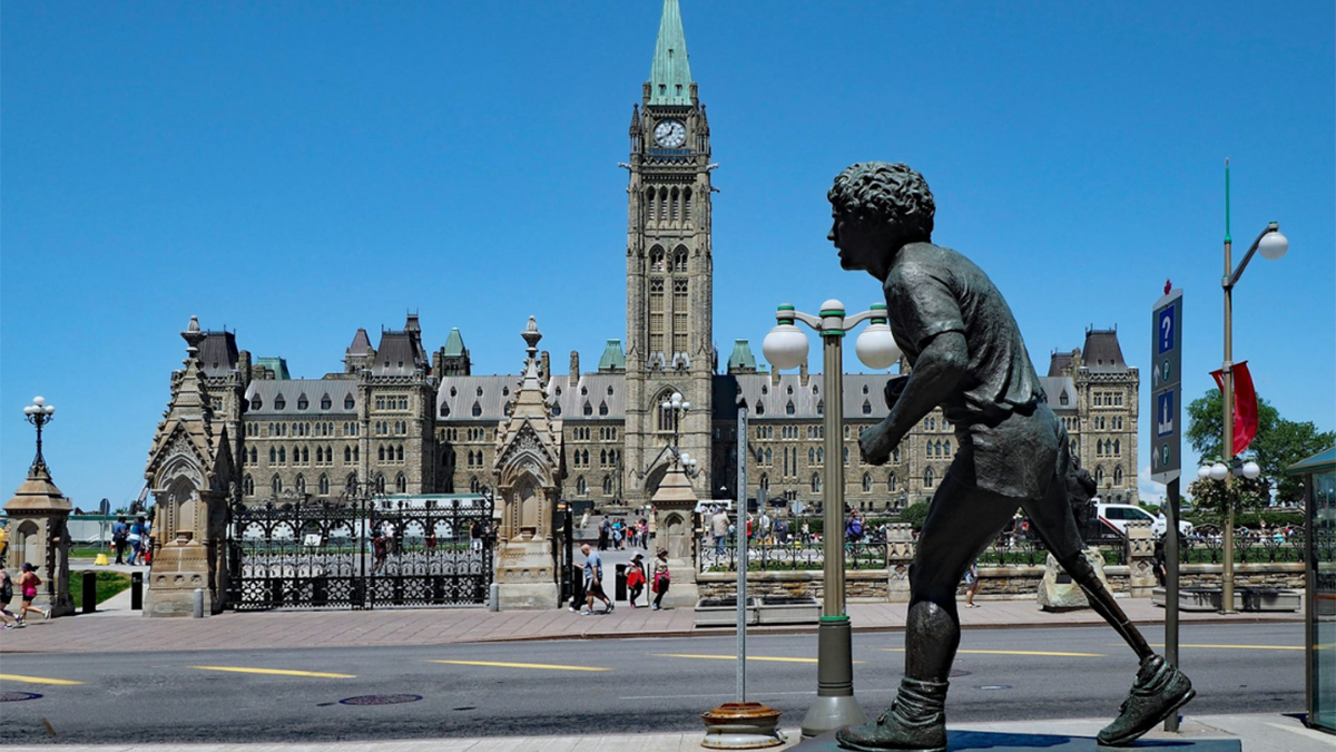 Ottawa's statue of Terry Fox in the foreground, with the Peace Tower and Parliament buildings in the background.