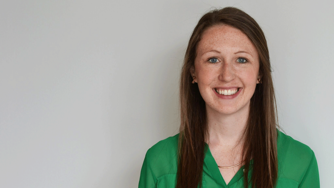 Kathleen Houlahan smiles to the camera. She is wearing a green blouse and a thin necklace, and has auburn hair.