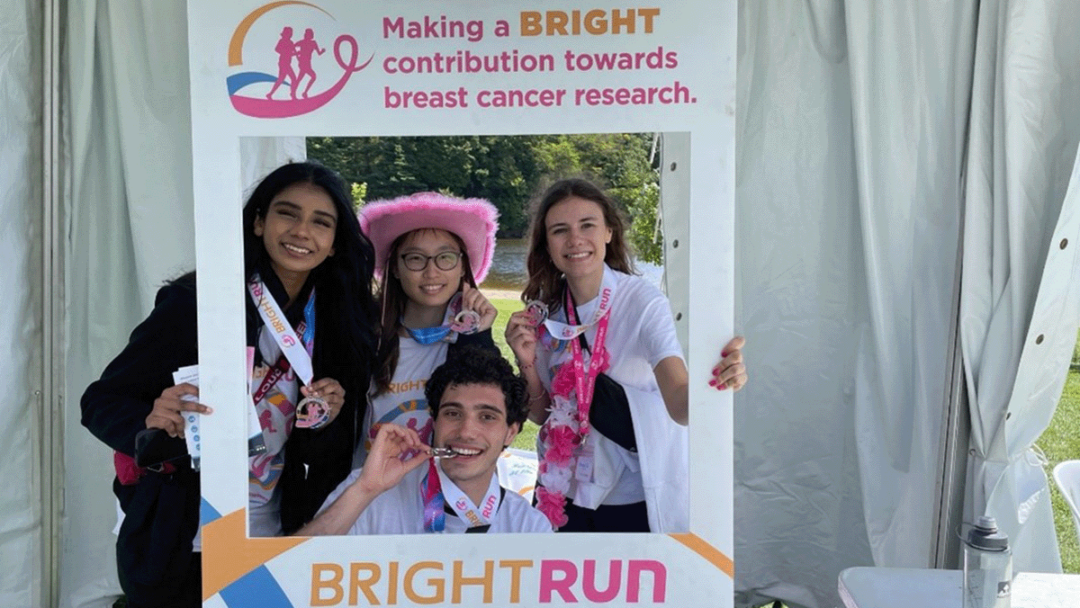 Members of McMaster University's iGEM team hold up a photo banner after taking part in the BrightRun even in Hamilton Ont.