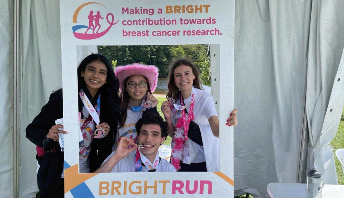 Members of McMaster University's iGEM team hold up a photo banner after taking part in the BrightRun even in Hamilton Ont.