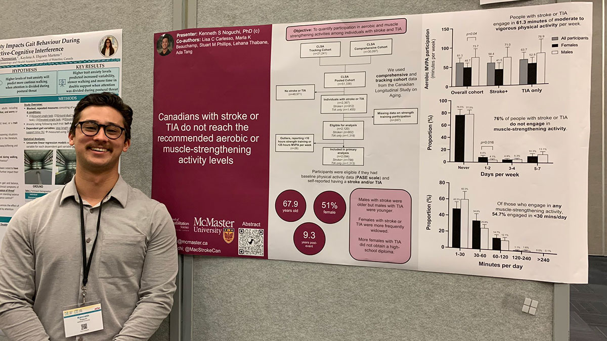 Kenny Noguchi stands in front of a research poster.