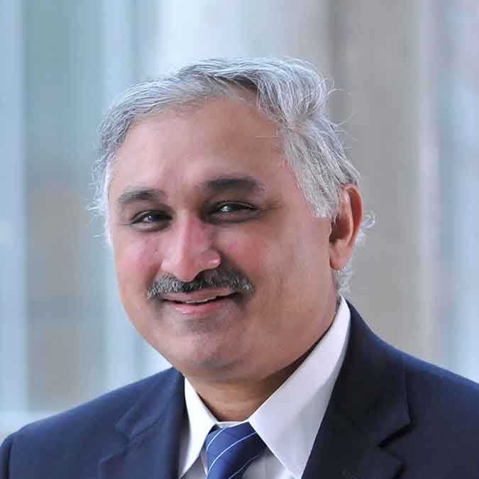 Parameswaran Nair smiles in a dark suit.