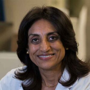 Roma Sehmi smiles in her office wearing a white lab coat.