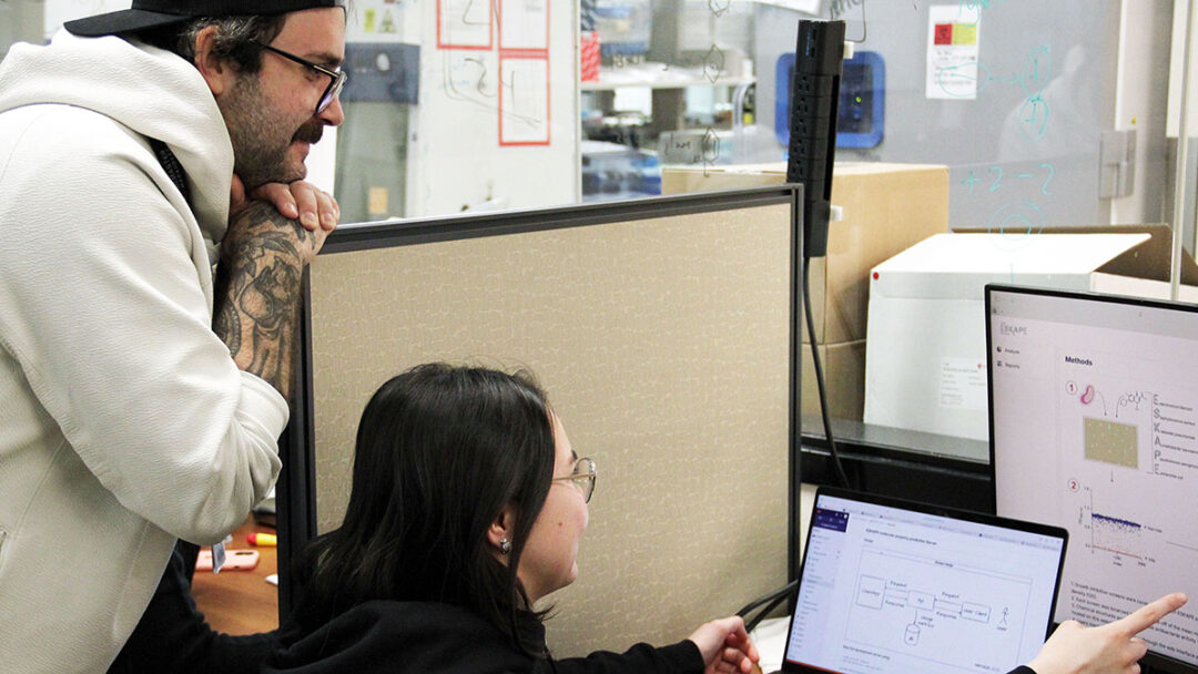 Jon Stokes and Autumn Arnold, the experts featured in this story, posing near a computer that displays their new AI model.