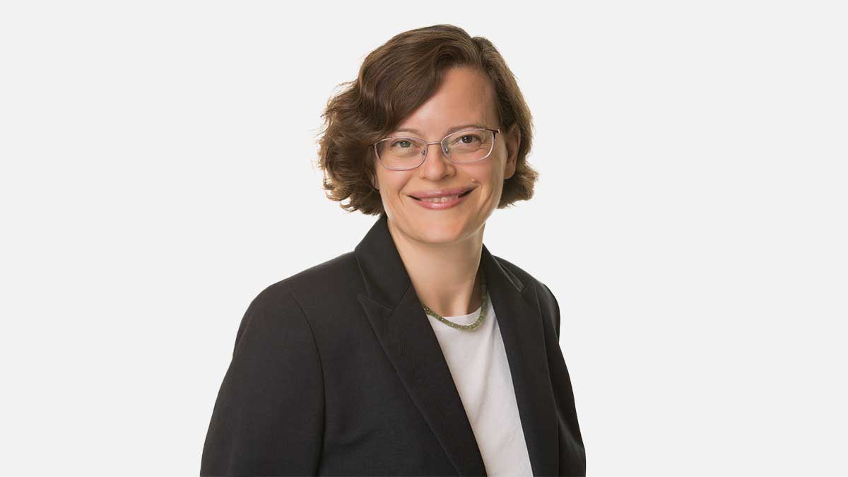 Katherine Zukotynski wears a black blazer and glasses smiling to the camera.